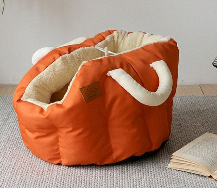 Orange pet bed with white interior on a textured surface