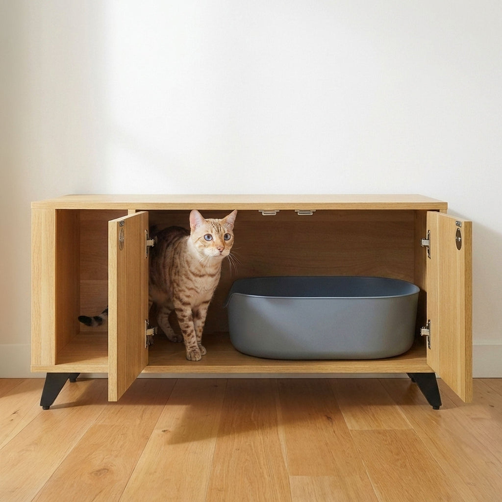 Cat peeking out from a wooden cabinet with a gray bowl inside on a wooden floor.