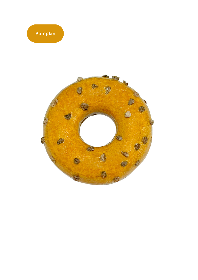 Yellow donut-shaped dog toy with studs on a white background