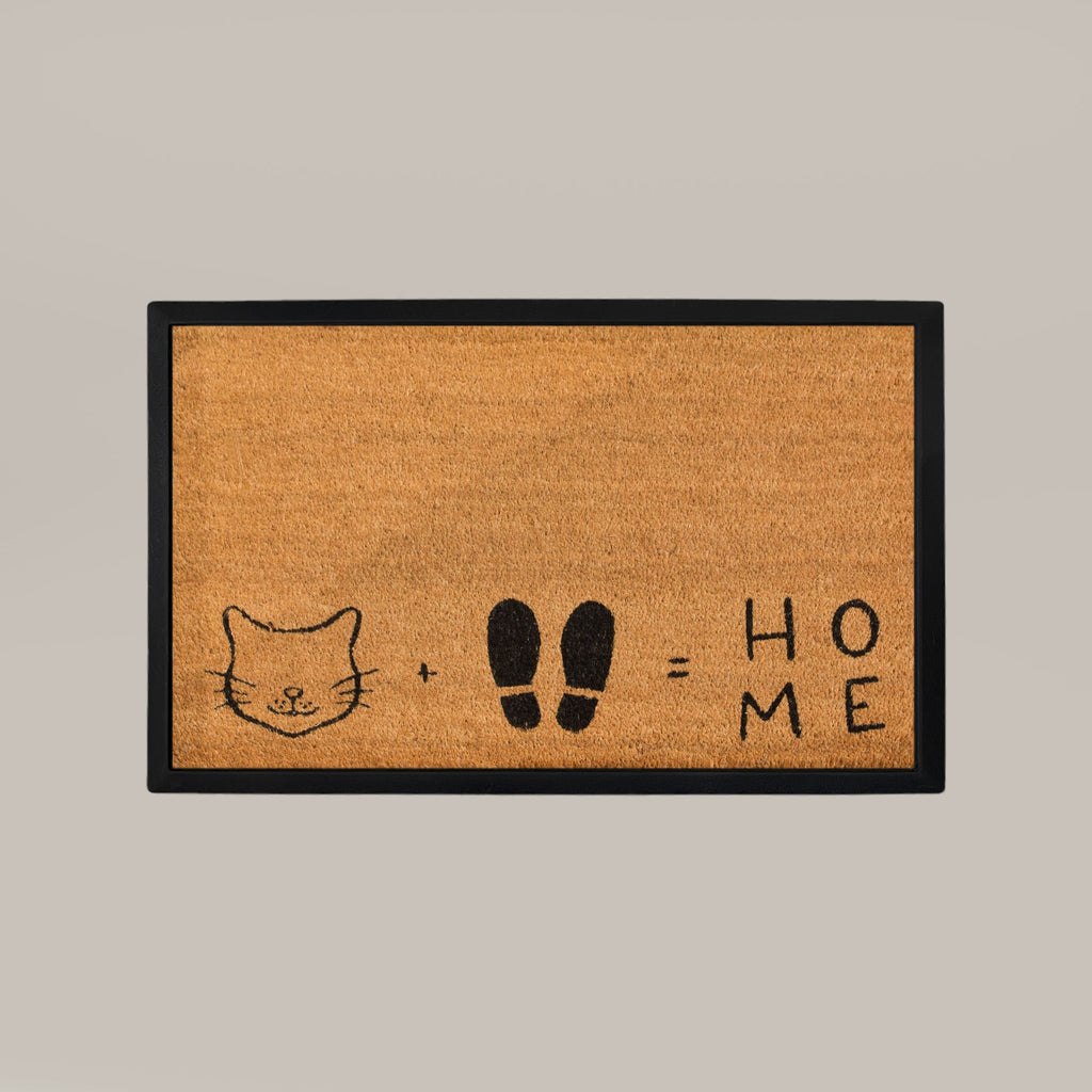 Doormat with a cat face, footprints, and 'HOME' text on a beige background