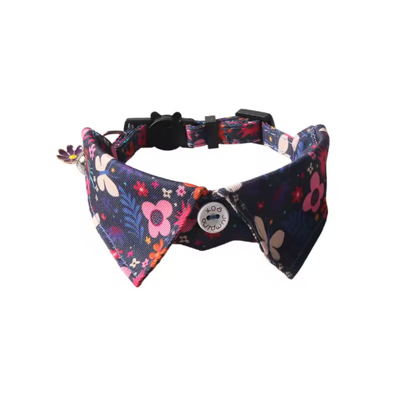 decorative floral bow tie collar with a silver bell, photographed against a clean white background.