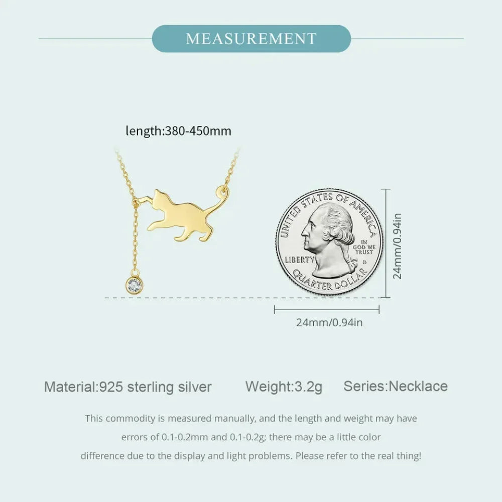Measurement details of a gold cat-shaped necklace with a quarter coin for scale on a white background.