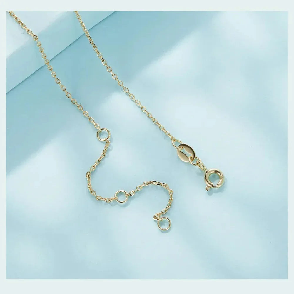 Gold necklace on a light blue background