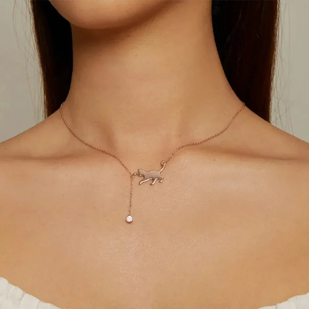Necklace with a cat pendant and pearl drop worn by a person