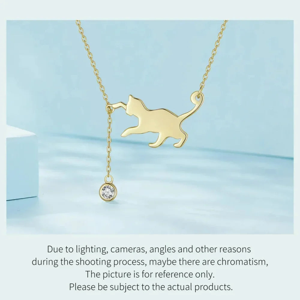 Gold cat-shaped pendant necklace on a light blue background