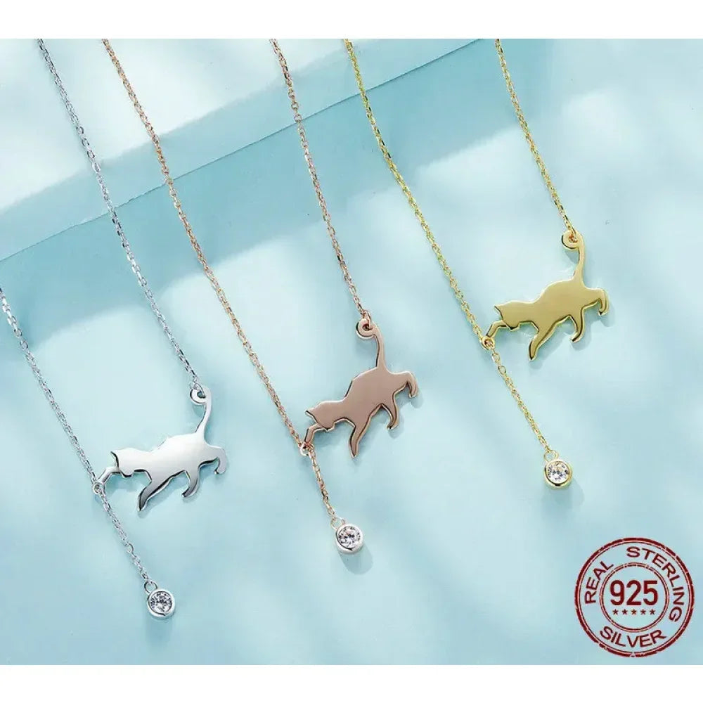 Three necklaces with dog pendants in silver, rose gold, and gold on a light blue background.