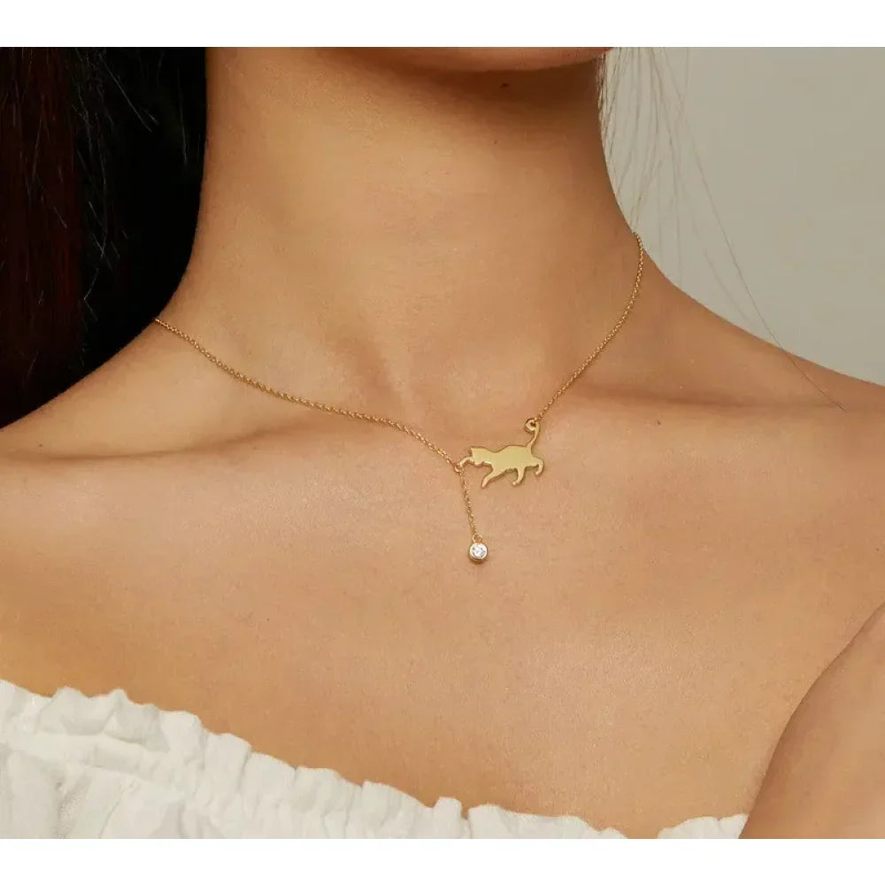 Gold necklace with a cat pendant worn by a person