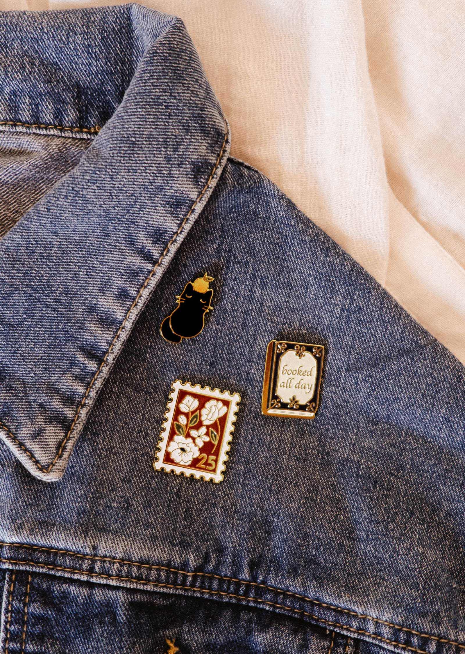 Denim jacket with decorative pins on a light background
