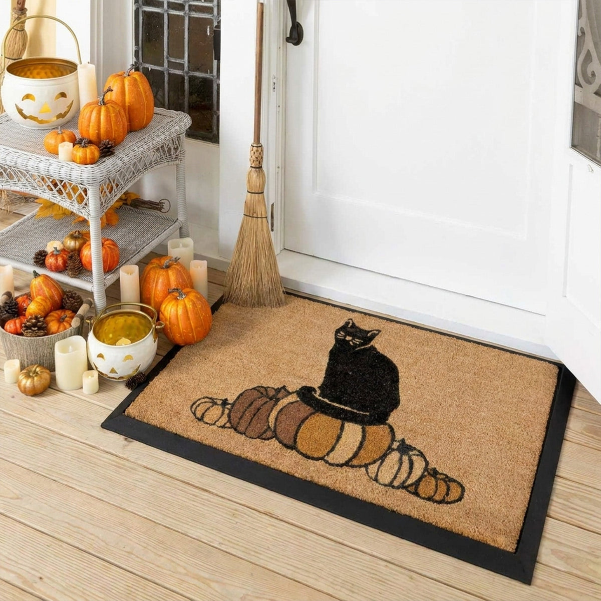Decorative doormat with a cat and pumpkins design on a wooden floor, surrounded by Halloween decorations.