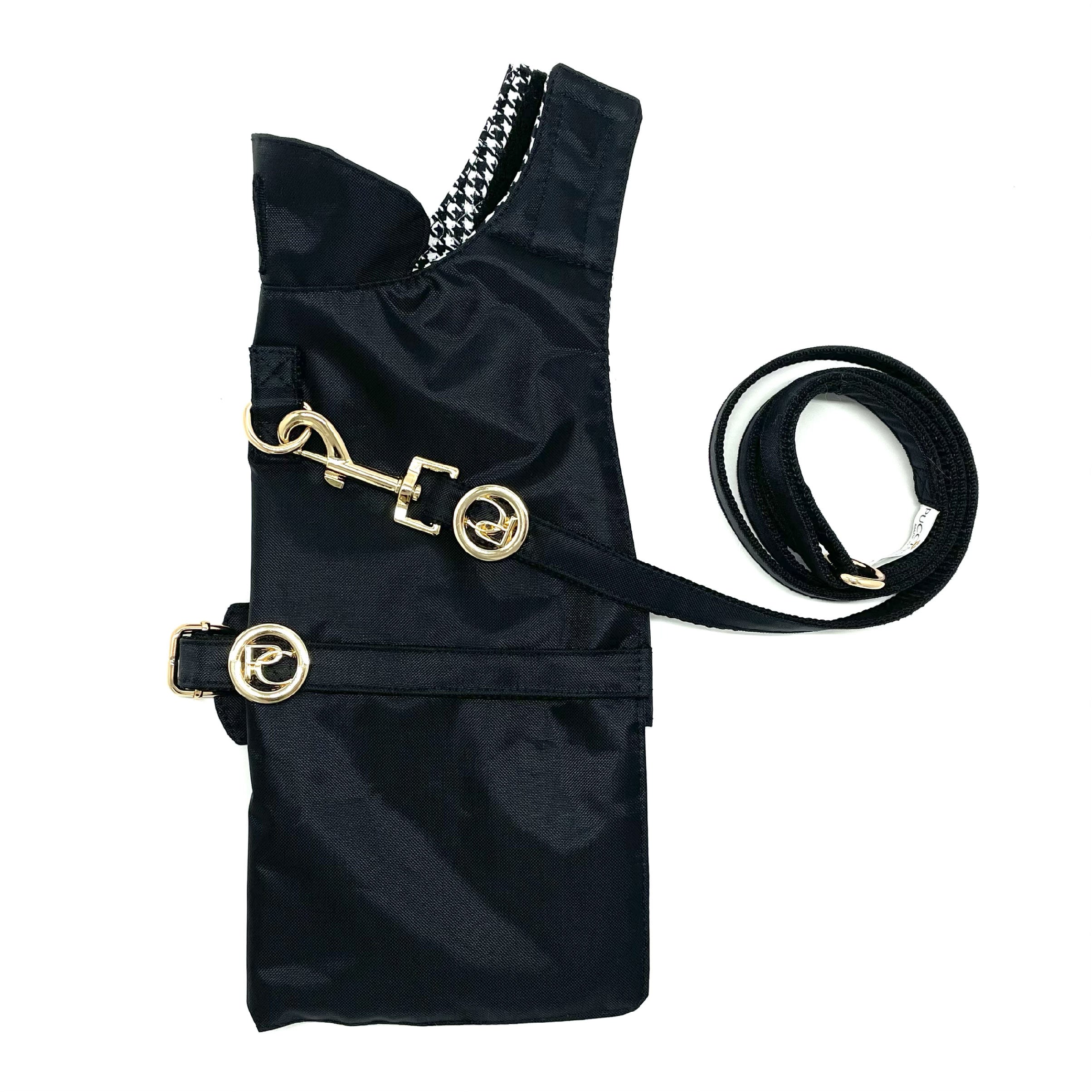 Black dog muzzle with gold hardware and a matching leash on a white background