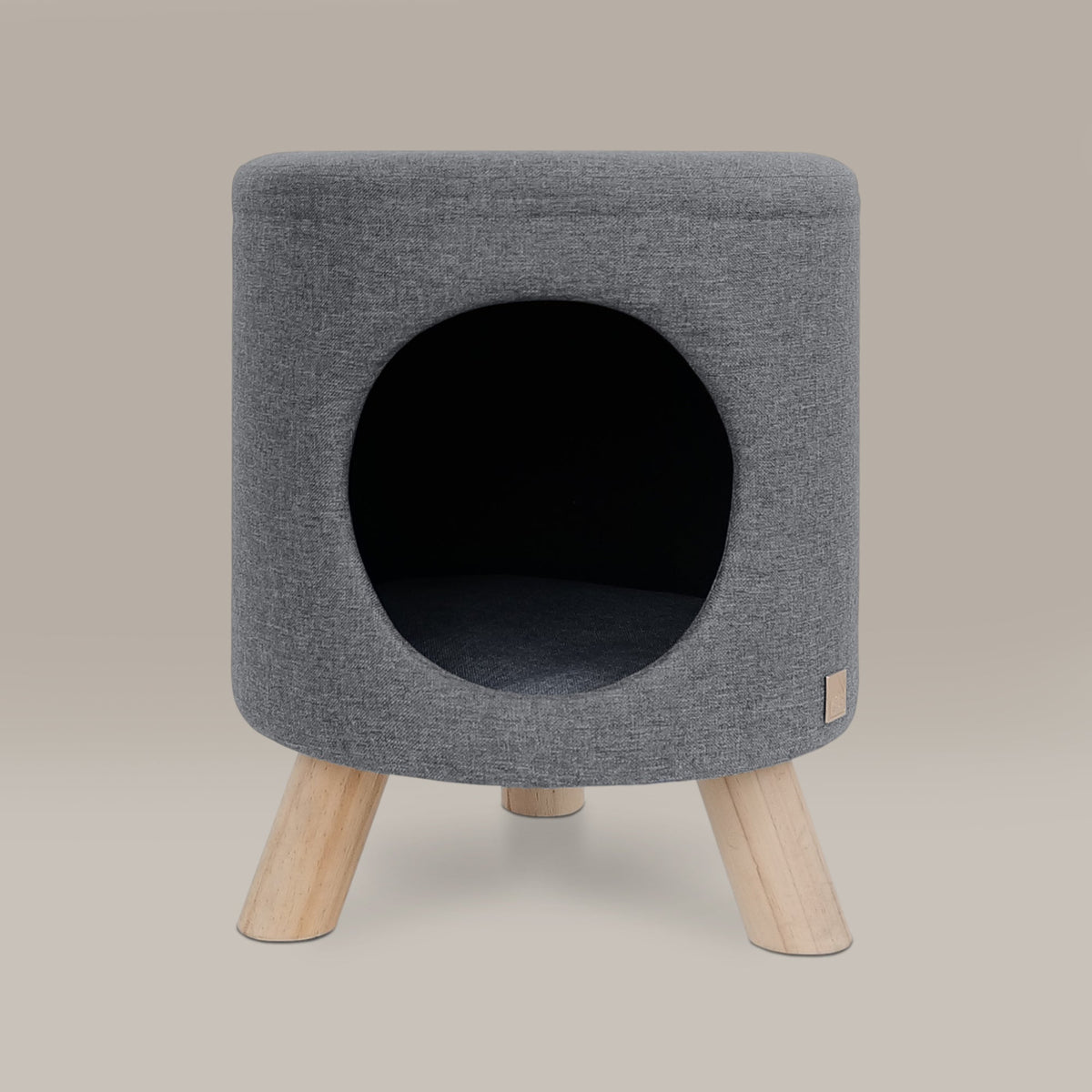Gray fabric pet bed with wooden legs on a beige background